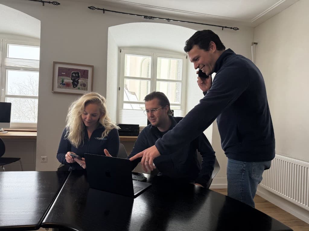 Kollegen arbeiten mit Telefon und Laptop zusammen